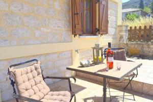 a table with a bottle of wine and a chair on a patio at Villa Araklis, Ithaca in Anoyí
