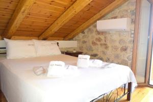 a bedroom with a white bed with towels on it at Villa Araklis, Ithaca in Anoyí