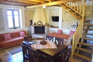 a living room with a table and a fireplace at Villa Araklis, Ithaca in Anoyí