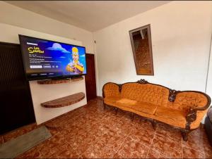 a living room with a couch and a flat screen tv at Casa Solar Boutique Eco-Hotel in Minatitlán