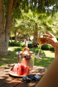 a person holding a glass of wine and a plate of watermelon at Casa Elia Datça in Emecik