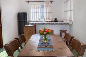 a kitchen with a wooden table with a vase of flowers on it at Casa Alma in Brisas de Zicatela