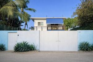 a white fence with a house behind it at Casa Alma in Brisas de Zicatela