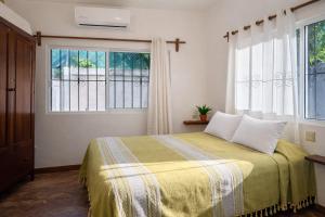 a bedroom with a bed and two windows at Casa Alma in Brisas de Zicatela