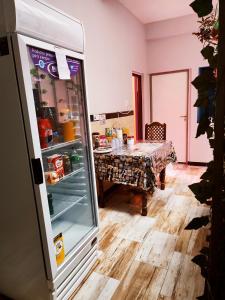 a kitchen with a refrigerator with a table in it at Hotel AEROPUERTO Jujuy in Perico