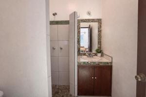 a bathroom with a sink and a mirror at Casa Alma in Brisas de Zicatela +11 photos