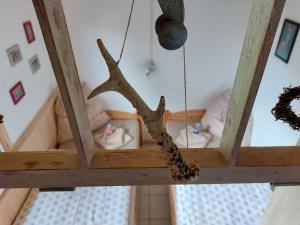 Ein Ast, der von der Decke eines Zimmers mit einem Kinderbett hängt. in der Unterkunft Kleine Jagdhütte in Zettemin