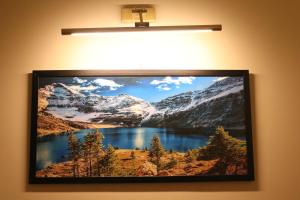 a picture hanging on a wall with a painting of a mountain at Designer Den two Bed apartment opposite to giga mall in Islamabad