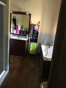 a bathroom with a sink and a tub and a mirror at Grande maison entre vert et bleu in Saint-Yrieix-la-Montagne