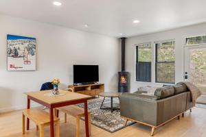 a living room with a couch and a tv at Bridger Bowl - Crosscut Hideaway in Bozeman