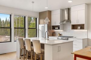 a kitchen with white cabinets and a kitchen island with chairs at Bridger Bowl - Crosscut Hideaway in Bozeman +63 photos