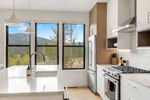 a kitchen with white appliances and a large window at Bridger Bowl - Crosscut Hideaway in Bozeman