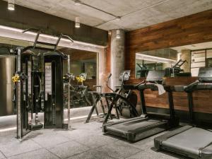 a gym with two tread machines and exercise bikes at Merchant LES Hotel in New York