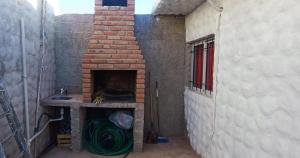 an alley with a brick oven with a pile of hose at Apart Fiambala alojamiento in Fiambalá