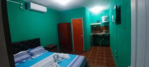 a green room with a bed and a sink at Apart Fiambala alojamiento in Fiambalá +3 photos