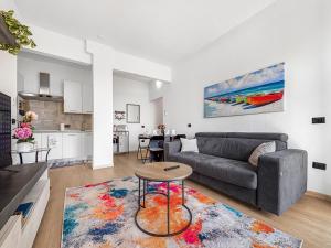 a living room with a couch and a table at Victoria Seafront - Sea View Private Parking AC & WiFi in Savona