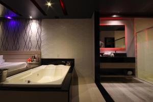 a bathroom with a bath tub and a sink at Motel Deslize Limeira 4 in Limeira