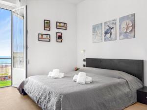 a bedroom with a large bed with two white towels at Victoria Seafront - Sea View Private Parking AC & WiFi in Savona