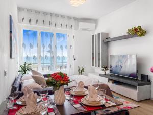 a living room with a table and a tv at Victoria Seafront - Sea View Private Parking AC & WiFi in Savona