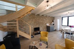 a living room with a staircase and a stone wall at TY BERNIC maison en Pierre, lumineuse, 2 à 4 pers à Riec Sur Belon in Riec-sur-Bélon