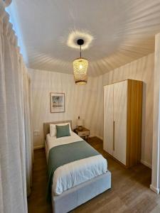 a bedroom with a bed and a chandelier at Opatio residence 1314 in Tamarin +22 photos