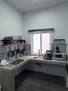 a kitchen with a sink and a microwave at los agaves lto in Loreto