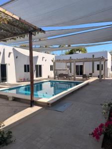 a swimming pool in front of a house at los agaves lto in Loreto