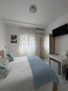 a bedroom with a bed and a desk and a television at Capri Melody in Anacapri