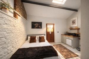 a bedroom with a bed and a brick wall at Copper Cove at Lough Sillan House - Adults only in Shercock