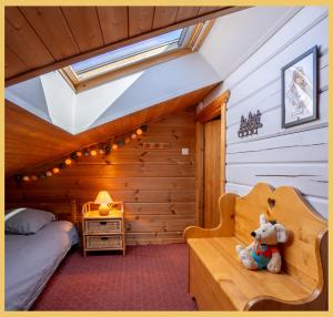 a teddy bear sitting on a bench in a room at Olaf Chalet IT5 I Les Gets in Les Gets