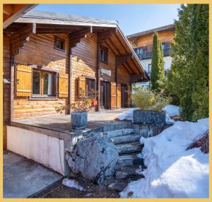 a log cabin with a porch in the snow at Olaf Chalet IT5 I Les Gets in Les Gets