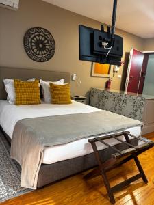 a bedroom with a large bed and a flat screen tv at Casas do Teatro in Porto
