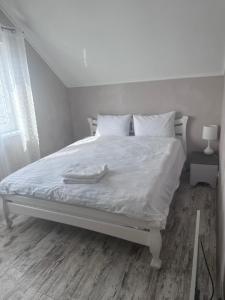 a white bed with white sheets and pillows on it at SeaLine Odessa in Kryzhanivka