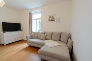 a living room with a couch and a tv at Stadtvilla Alpenliebe in Bad Reichenhall