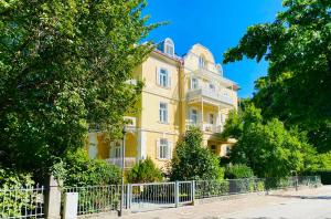 a yellow house with a fence in front of it at Stadtvilla Alpenliebe in Bad Reichenhall