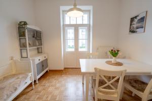 a white dining room with a table and chairs at Stadtvilla Alpenliebe in Bad Reichenhall