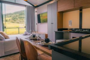 a room with a table and a kitchen with a view at Monakó Cabanas in Bragança Paulista
