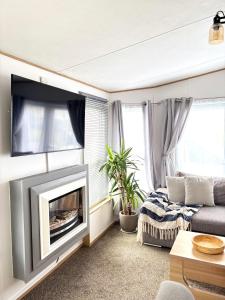 a living room with a fireplace and a couch at Seven Bays Hideaway in Saint Merryn