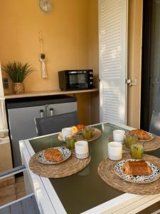a kitchen with three plates of food on a table at Coudou Beach T2 cosy à 2 pas de la mer in Six-Fours-les-Plages
