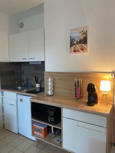 a kitchen with white cabinets and a wooden counter top at Coudou Beach T2 cosy à 2 pas de la mer in Six-Fours-les-Plages +32 photos