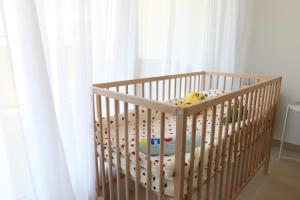 a crib with a toy in it next to a window at Nice Time - Chic Apartment with sunny terrace, Nice Port in Nice