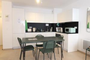a table and chairs in a kitchen with white cabinets at Nice Time - Chic Apartment with sunny terrace, Nice Port in Nice +24 photos