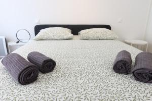 a bed with purple towels on it with two pillows at Nice Time - Chic Apartment with sunny terrace, Nice Port in Nice