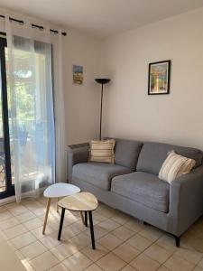 a living room with a gray couch and a table at Coudou Beach T2 cosy à 2 pas de la mer in Six-Fours-les-Plages