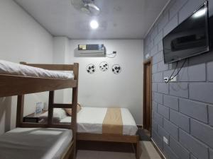 a room with two bunk beds and a tv at Hotel Cabañas Mar Caribe in Necoclí