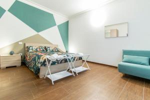 a bedroom with a bed and a blue couch at ANTONELLI Apartment L'AQUILA in LʼAquila
