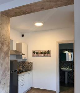 a kitchen with white cabinets and a sink at Roccazzo 16 in Cefalù +14 photos