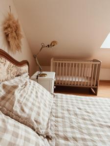 a bedroom with a bed with a crib and a lamp at Le gîte de Marceau in Labergement-lès-Auxonne