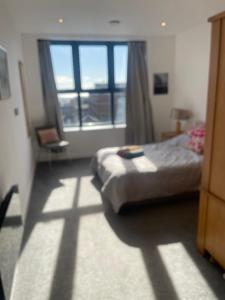 a bedroom with a bed and a window at Top-end penthouse with sea views and free parking in Ramsgate