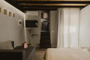 a bedroom with a bed and a couch and a window at Al Cortile Del Seminario in Cefalù